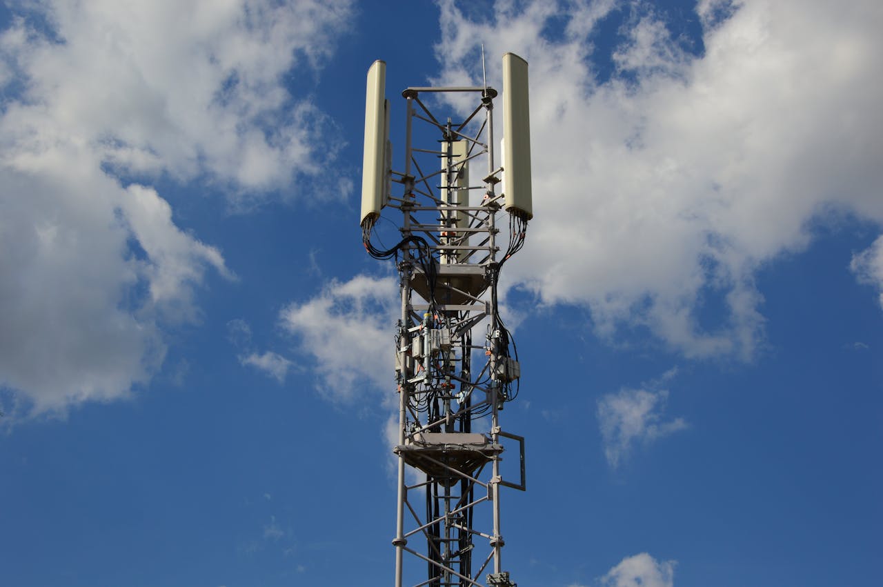 Offerings A tall cellular communication tower against a vivid blue sky, symbolizing modern technology.
