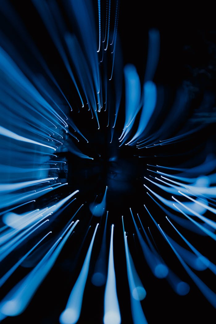 Offerings Dynamic abstract image showcasing blue light streaks captured in motion with a dark background.